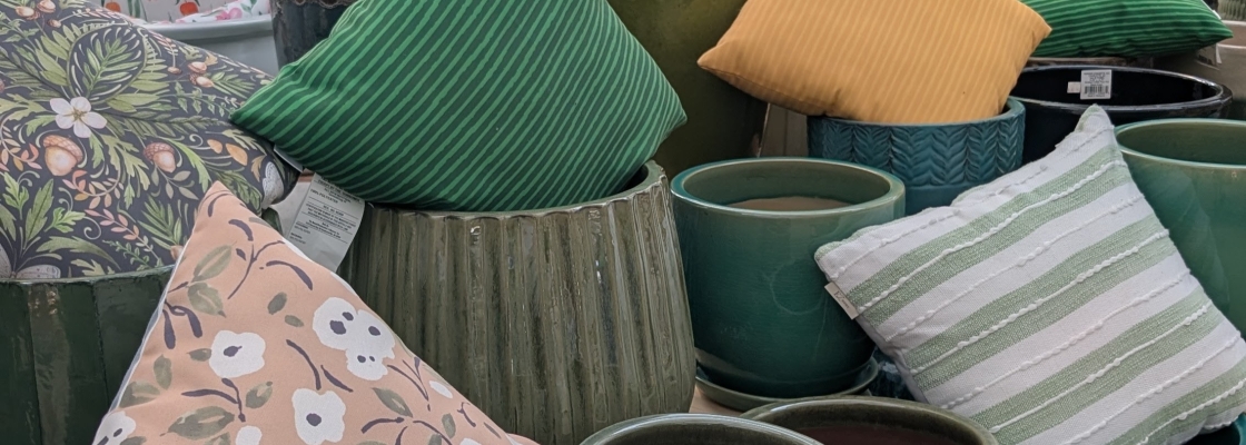 Display of outdoor pottery and pillows.