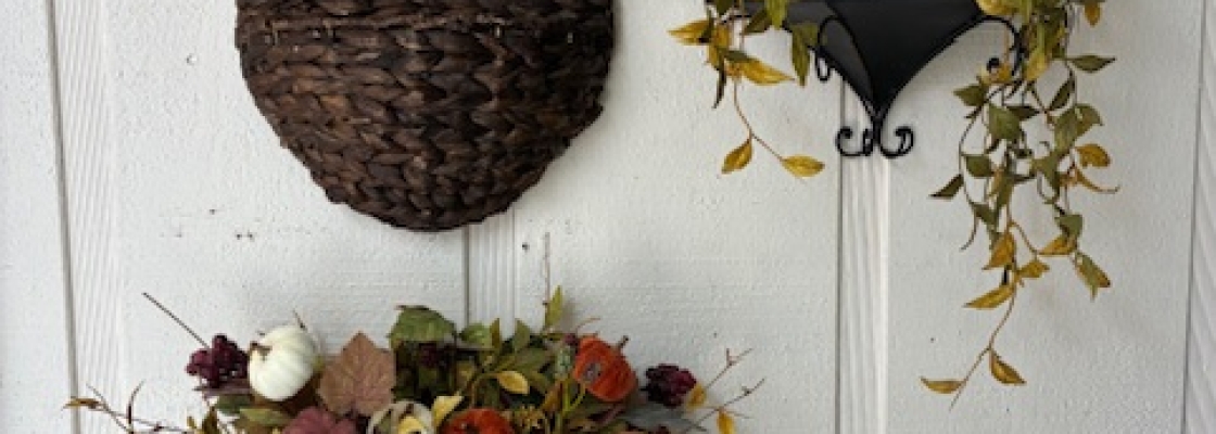 Three different wall sconces/holders, two of which have fall themed silk flowers.